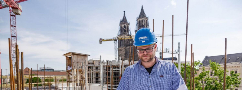 Bild von einem Bauleiter auf einer Baustelle mit dem Magdeburger Dom im Hintergrund